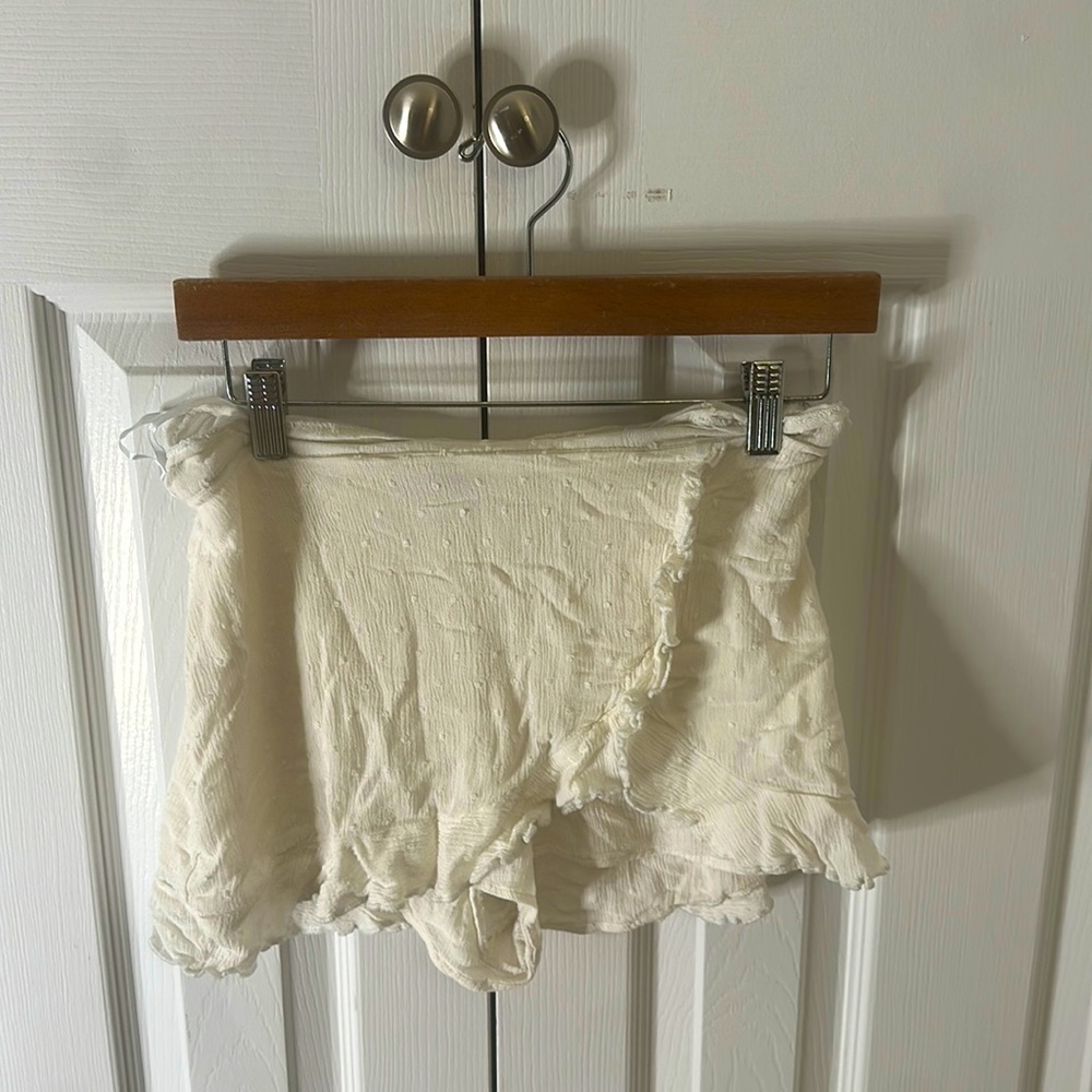 White skirt with shorts underneath. Has almost polka dot sewing’s on it